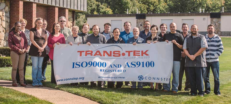 photo of trans-tek, inc. team holding banner, iso certified, ISO9000 and AS9100